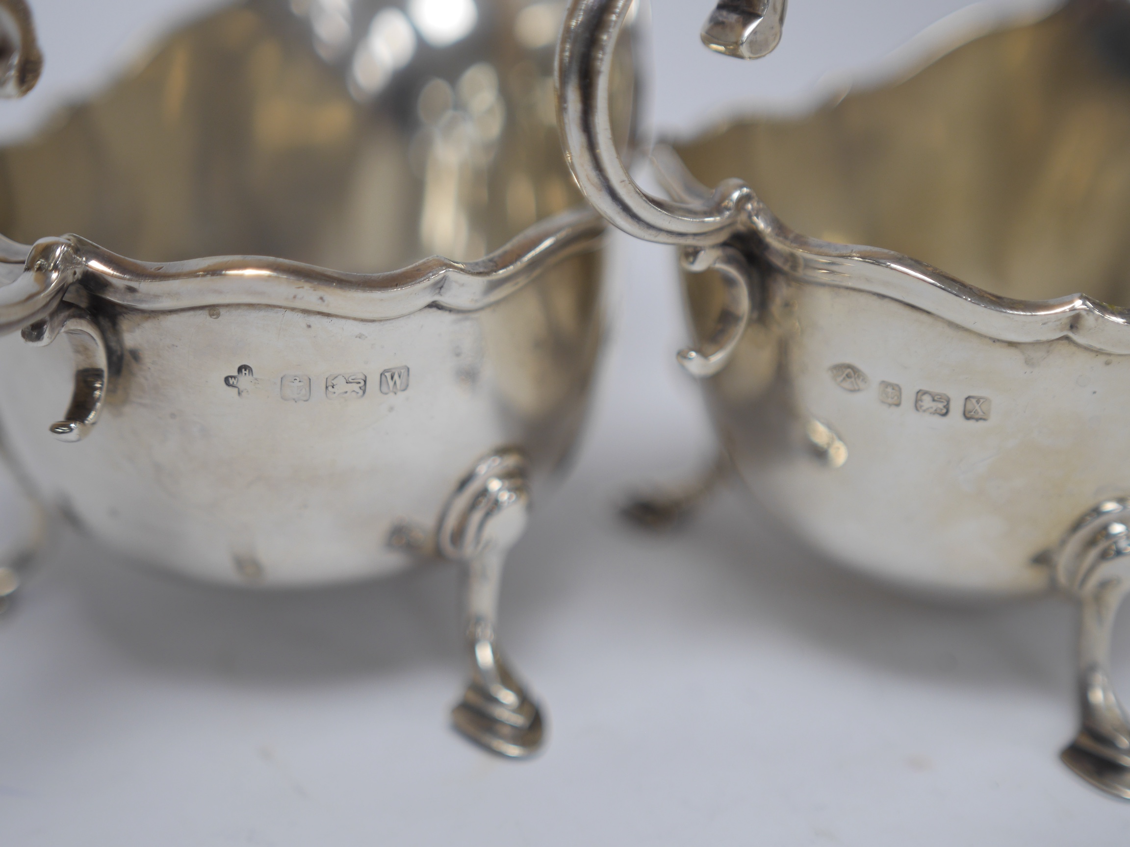 A matched pair of George V silver sauceboats, Horace Woodward & Co Ltd, Birmingham, 1921 and Adie Bros. Birmingham, 1922, 13.3oz. Condition - fair to good